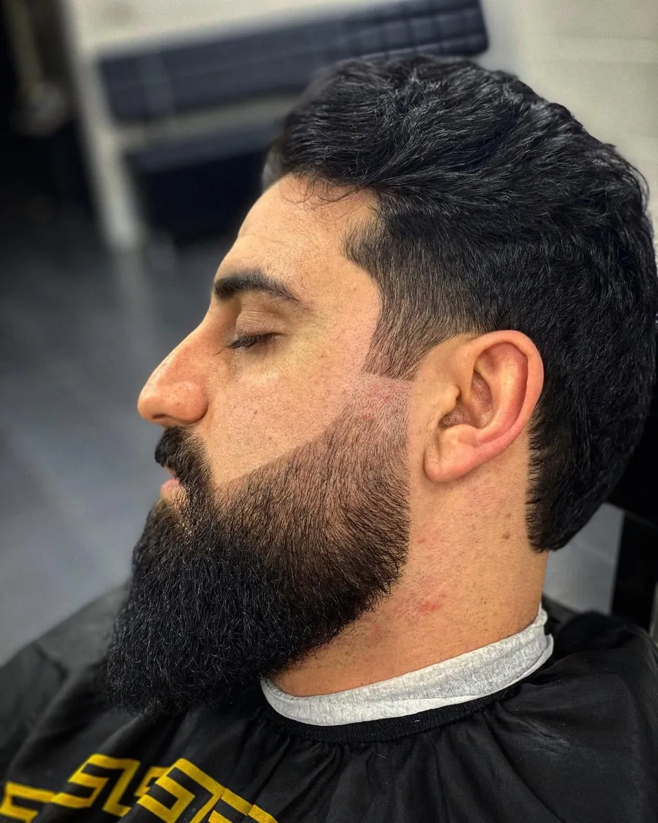 Volle baard strak gemodelleerd, met getailleerd kapsel, zijprofiel