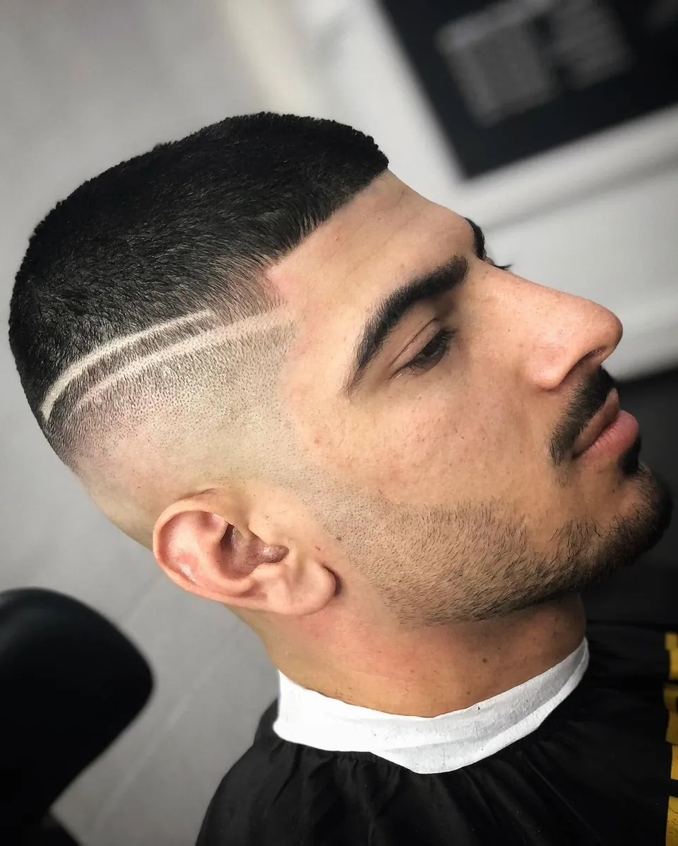 Heren skin fade met een geschoren lijn als accent, zijprofiel